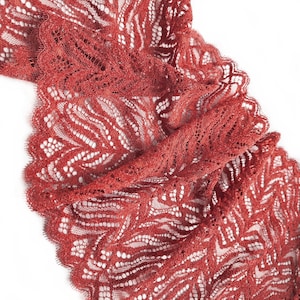 Könnte beinhalten: Rote Spitzenborte mit einem zarten Blumenmuster.