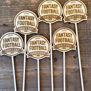 May include: Wooden Fantasy Football Draft Day signs. Each sign features a football graphic and the text "FANTASY FOOTBALL DRAFT DAY -2025-". The signs are on a wooden background.