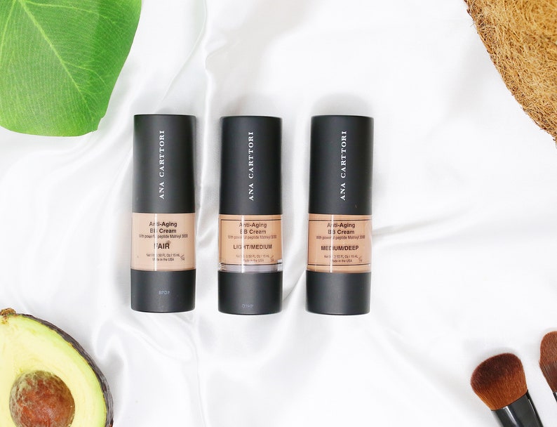 Op de afbeelding: Drie flessen Ana Carttori Anti-Aging BB Cream in de tinten Licht, Licht/Medium en Medium/Donker.