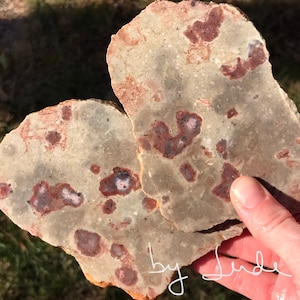 Two slabs of gray speckled jasper with raspberry pink/red bursts of color throughout