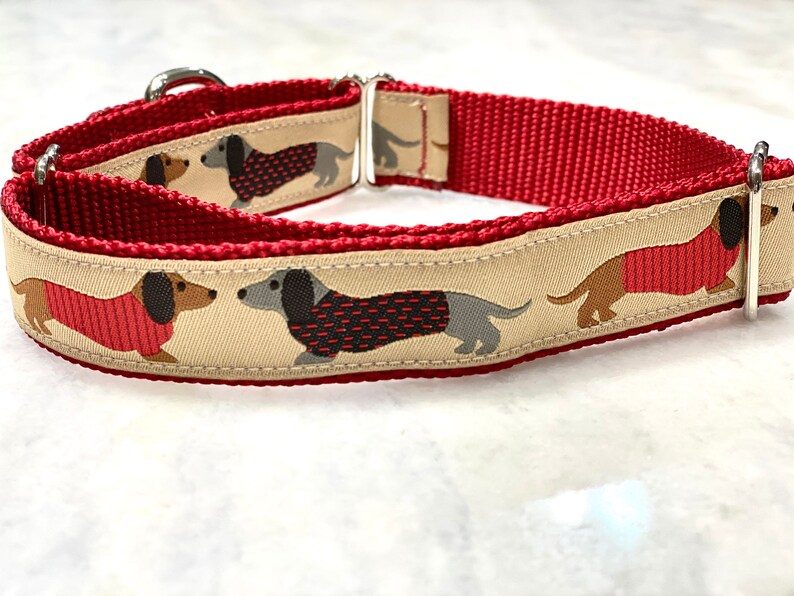 May include: Red and beige dog collar with a pattern of dachshunds wearing red sweaters.
