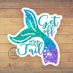 May include: A turquoise and purple glitter mermaid tail with the text "Get off my tail" on a wood background.