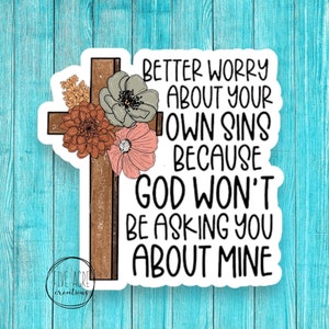 May include: A sticker with a floral design and a wooden cross. The sticker has the text "Better worry about your own sins because God won't be asking you about mine".
