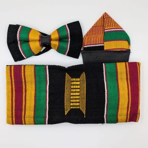 May include: A set of African-inspired accessories, including a bow tie, a head wrap, and a head covering. The bow tie features a black base with green, yellow, and red stripes. The head wrap and head covering have similar patterns.