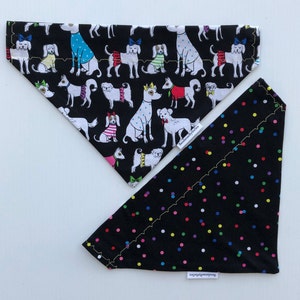 May include: Two dog bandanas, one with a black background and a colorful polka dot pattern, and the other with a black background and a white dog pattern wearing colorful clothes. Both bandanas have the text "BandanasByBrenda" on them.