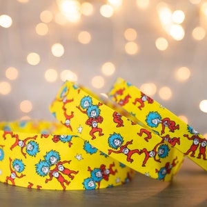 May include: Three yellow fabric headbands with a repeating pattern of red and blue figures from the book "The Cat in the Hat".