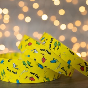 May include: Three yellow wristbands with a repeating pattern of red fish, blue fish, and the text "One fish, two fish, red fish, blue fish".