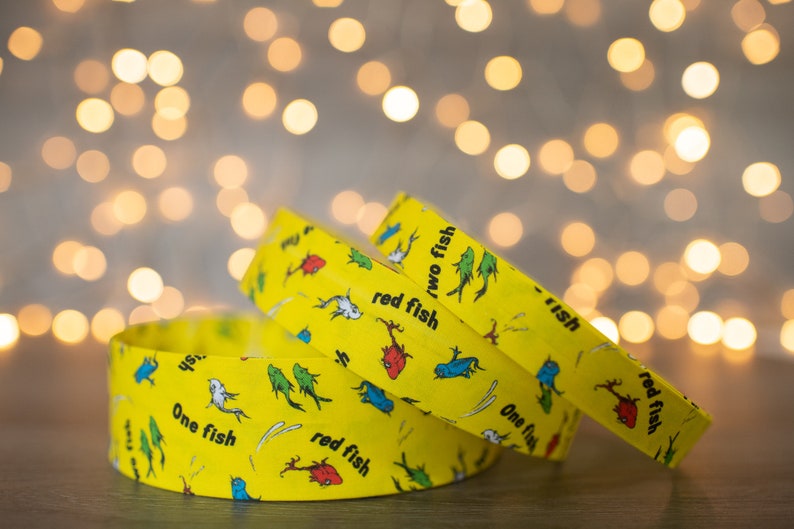 May include: Three yellow wristbands with a repeating pattern of red fish, blue fish, and the text "One fish, two fish, red fish, blue fish".