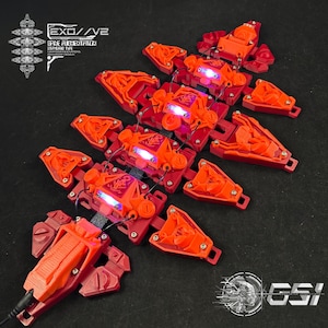 Puede incluir: Componentes mecánicos rojos y naranjas con luces LED azules. Los componentes están dispuestos en un patrón, con el texto "EXO//V2 SPINE AUGMENTATION STANDARD TYPE" visible en el lado izquierdo. El logotipo de GSI está en la parte inferior derecha.