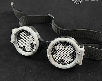 May include: Silver and black universal tech goggles with a cross-shaped pattern on the lenses. The goggles have adjustable black straps and are labeled "SPEKT-R//V3 Universal Tech Goggles."
