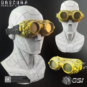 May include: Obscura Version 1.0 goggles featuring a weathered yellow finish with a black strap and hexagonal mesh lenses. The goggles are displayed on a white geometric mannequin head, showing a detailed mechanical design with textured surfaces.
