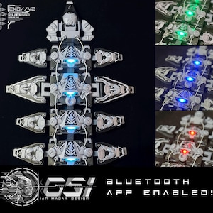 May include: A white, segmented, modular, wearable device with blue LED lights. The device is connected to a Bluetooth app. The text "EXO//VE", "GSI", "IAN MADAY DESIGN", "BLUETOOTH", "APP ENABLED!" is visible on the image.