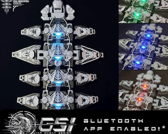 May include: A white, segmented, modular, wearable device with blue LED lights. The device is connected to a Bluetooth app. The text "EXO//VE", "GSI", "IAN MADAY DESIGN", "BLUETOOTH", "APP ENABLED!" is visible on the image.
