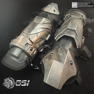 May include: Pair of metallic gray and black protective arm and elbow guards. The guards have a textured, angular design with straps and buckles for secure attachment. The image includes the text "GRAYSTAR INNOVATIONS" and "GSI".