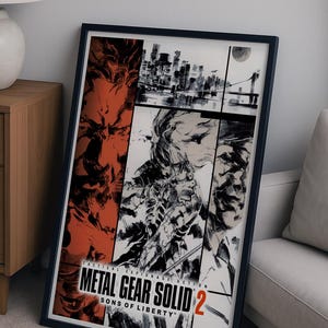 May include: Framed Metal Gear Solid 2: Sons of Liberty poster. The artwork features a collage of images in red, black, and white, with the game's title prominently displayed. The poster is in a black frame.