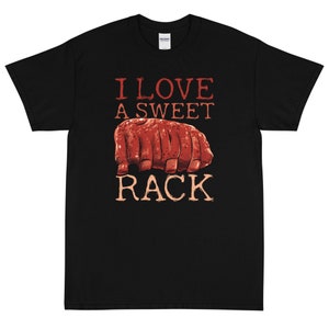 Puede incluir: Camiseta negra con una ilustración roja de una costilla de cerdo y el texto "Me encanta una costilla dulce".