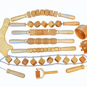 Può includere: Un set di strumenti per massaggio in legno chiaro, tra cui rulli, un massaggiatore manuale e uno strumento gua sha. Progettati per il massaggio del corpo e il relax, presentano diverse forme e dimensioni per varie tecniche di massaggio.