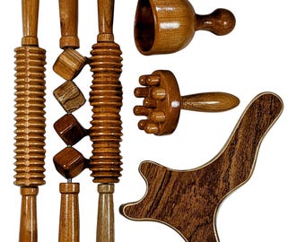 Könnte beinhalten: Eine Sammlung von Massage-Werkzeugen aus Holz, darunter Rollen, ein becherförmiger Massager, ein Massager mit mehreren Knöpfen und ein gebogenes Gua-Sha-Werkzeug. Die Werkzeuge bestehen aus hellem und dunklem Braunholz mit natürlichen Maserungen. Für Körpermassagen.