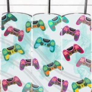 May include: A white tumbler featuring a colourful pattern of video game controllers. The controllers are in various colours, including red, blue, green, yellow, and purple. The background is a light blue with white stripes.
