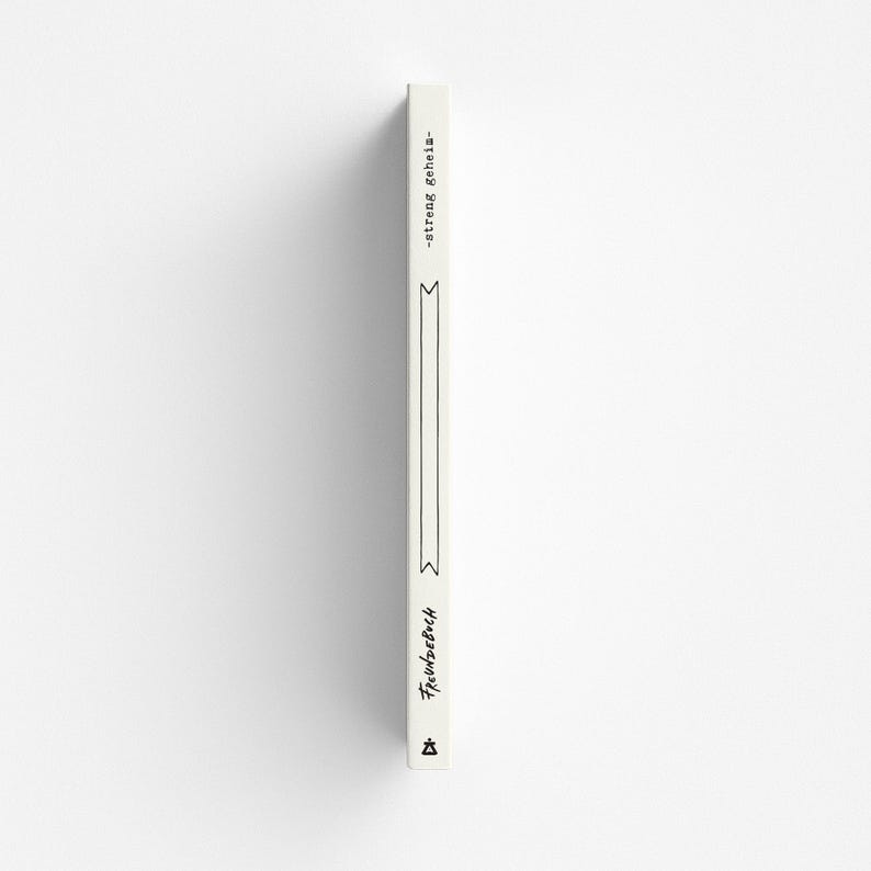 May include: A vertical, off-white book spine with black text and decorative elements. The text reads "-streng gehein-" and "Freundebuch". A long, thin rectangle and two stylized ribbon shapes are also visible.