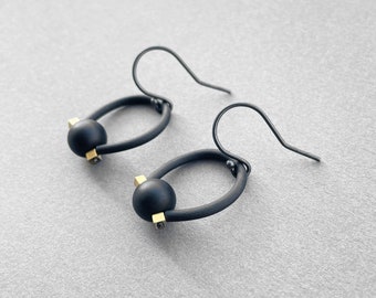 Black onyx drop earrings with oxidized sterling silver hooks, matte black rubber and hematite with shiny golden finish.