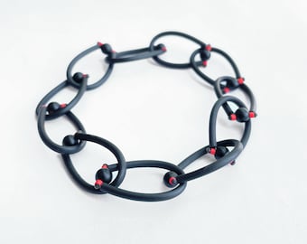 Black chain bracelet made of rubber, matte onyx and red miyuki seed beads. Lightweight, waterproof and stretchable link bracelet.