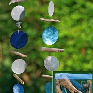 May include: Two vertical hanging garlands composed of alternating circular blue and silver shell discs interspersed with pieces of light brown driftwood. A clear plastic bag containing the disassembled components of the garlands is shown.