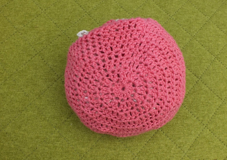 May include: A pink crocheted hat with a white crocheted lining.