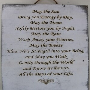 May include: A white wooden sign with a distressed finish and a jute rope for hanging. The sign features engraved text that reads "May the Sun...All the Days of your Life."
