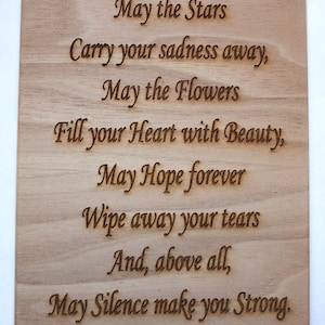 May include: A rectangular wooden plaque with engraved text. The text reads, "May the Stars Carry your sadness away, May the Flowers Fill your Heart with Beauty, May Hope forever Wipe away your tears And, above all, May Silence make you Strong."