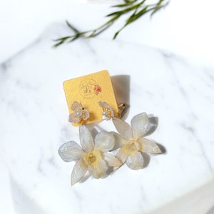 Gouden clipoorbellen met echte witte orchidee, bewaard in hars met imitatiebloemblaadje en nepparel| handgemaakt| damessieraden| bruiloft| bruid