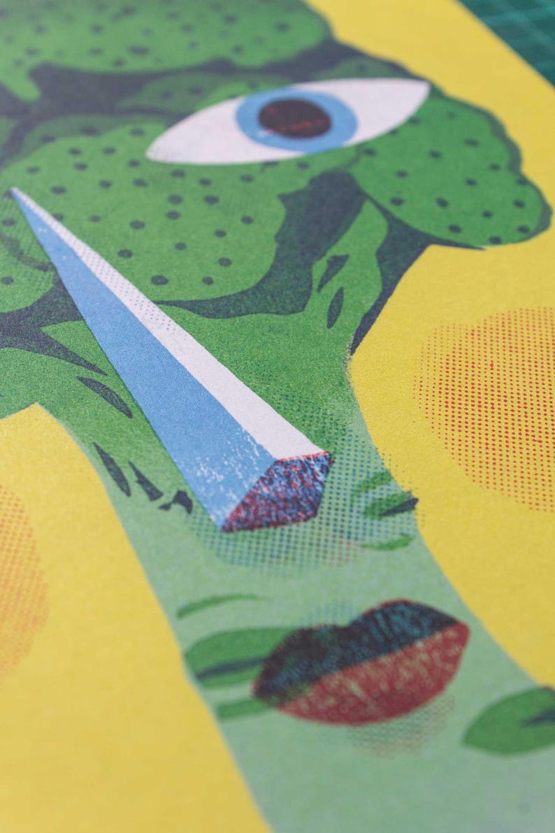 Pode incluir: Close-up de uma ilustra&ccedil;&atilde;o verde e azul de um rosto com um &uacute;nico olho e um objeto grande, azul e pontudo na frente do olho. O fundo &eacute; amarelo com bolinhas vermelhas e brancas.