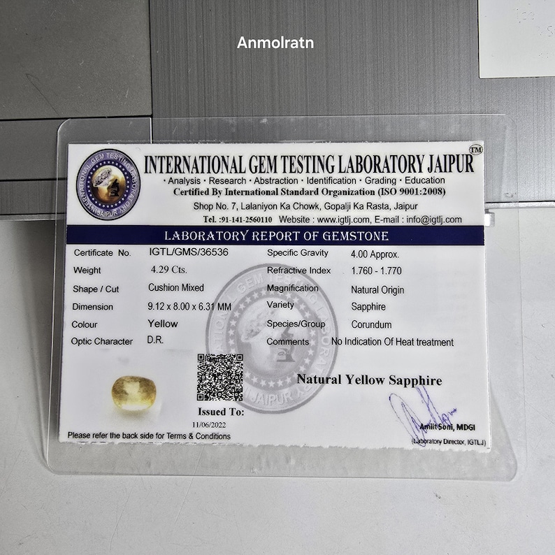 Op de afbeelding: Een wit laboratoriumrapport van het International Gem Testing Laboratory Jaipur voor een natuurlijke gele saffier. Het document vermeldt een gewicht van 4,29 karaat, een cushion mixed slijpvorm, afmetingen van 9,12 x 8,00 x 6,31 mm.