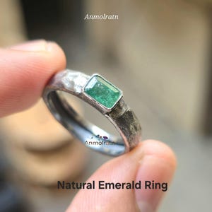 K&ouml;nnte beinhalten: Ein silberner Ring mit einer strukturierten Band und einem gr&uuml;nen Smaragd.