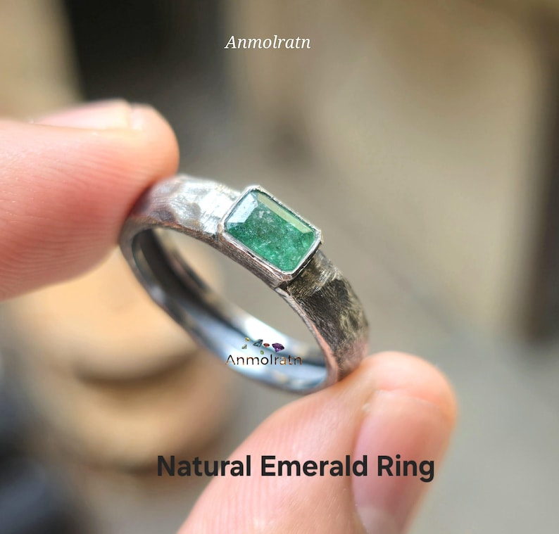 K&ouml;nnte beinhalten: Ein silberner Ring mit einer strukturierten Band und einem gr&uuml;nen Smaragd.