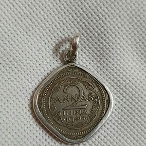 Op de afbeelding: Zilveren hanger met een vintage Indiase 2 annas munt uit 1946. De munt heeft een vierkante vorm met afgeronde hoeken en bevat de tekst "2 annas" en "India 1946".