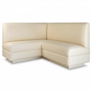 May include: Cream-colored, corner booth seating. The upholstered furniture features a low profile, with a rectangular base and a curved back. The seams are accented with a lighter color. The design is modern and minimalist.