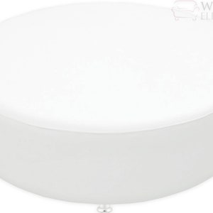 A large, round, upholstered ottoman bench with a smooth, flat top, designed as a centerpiece or additional seating. The ottoman is shown in a sleek, white leatherette fabric and rests on small, discreet feet. It measures approximately 54 inches in diameter and 17 inches in height.