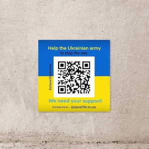 以下が含まれることがあります： ウクライナ国旗の色である青と黄色の正方形のステッカー。ステッカーには「ウクライナ軍を助けて戦争を止めよう」と「あなたのサポートが必要です！」というテキストとQRコード、ハッシュタグ#staywithukraineが記載されています。