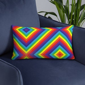 May include: A colorful rainbow patterned throw pillow with a geometric design. The pillow is yellow, red, orange, green, blue, indigo, and violet.