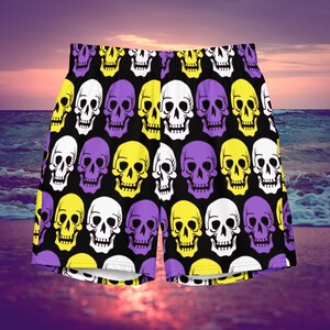 May include: Black swim trunks with a repeating pattern of yellow, purple, and white skulls.