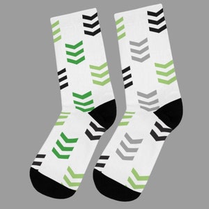 May include: A pair of white socks with a black, green, and gray arrow pattern.