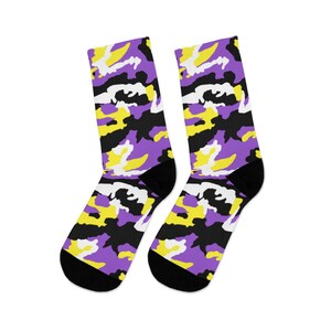May include: A pair of black socks with a camouflage pattern in purple, yellow, and white.