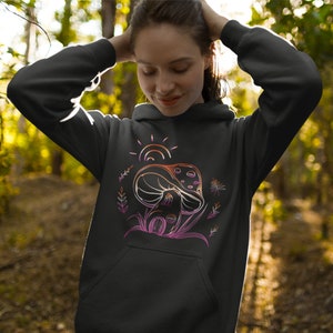 May include: Black hoodie with a graphic of a mushroom with a sun and leaves in pink, orange, and yellow.