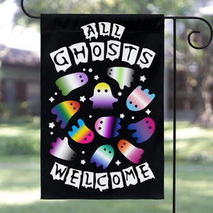 May include: A black garden flag with the text "All Ghosts Welcome" in white. The flag features a circle of colorful ghosts with rainbow, transgender, and genderfluid pride flags.