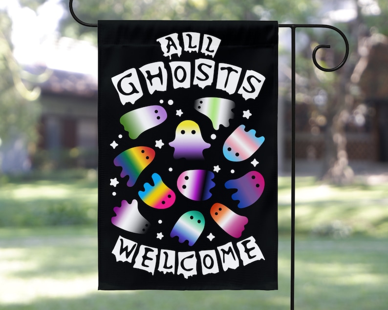 May include: A black garden flag with the text "All Ghosts Welcome" in white. The flag features a circle of colorful ghosts with rainbow, transgender, and genderfluid pride flags.