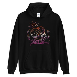 May include: Black hooded sweatshirt with a graphic of a mushroom house with a sun and flowers in a gradient of pink, orange, and yellow.