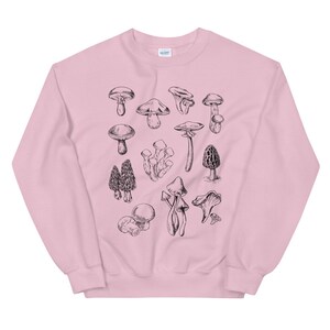May include: A pink sweatshirt with a black and white illustration of various types of mushrooms.