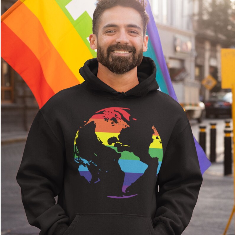 Pode incluir: Um moletom preto com um gr&aacute;fico de globo terrestre arco-&iacute;ris na frente. O globo &eacute; uma silhueta com as cores do arco-&iacute;ris sobrepostas.