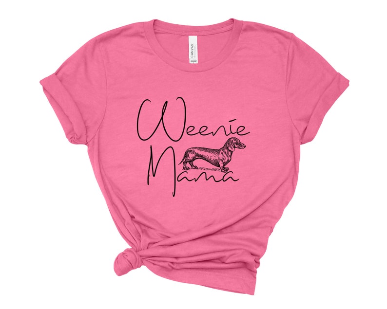 May include: Pink t-shirt with a black graphic of a dachshund and the text "Weenie Mama".